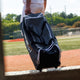 Player rolling the Marucci Stockade Wheeled Duffel Bag onto the field