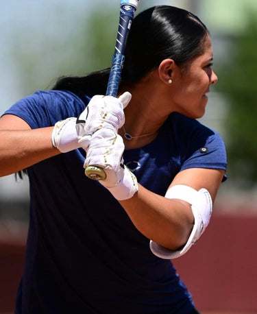 Fastpitch player hitting while wearing theEvoshield Carbyne Adult Batting Glove with Strap - White