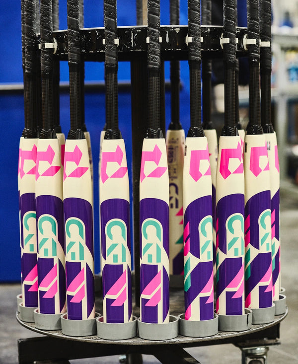 Multiple 2026 DeMarini CF® FE Fastpitch Bats on an assembly line staging area