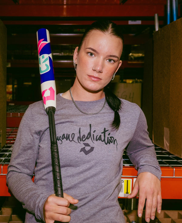 Player relaxing while holding the 2026 DeMarini CF® FE Fastpitch Bat
