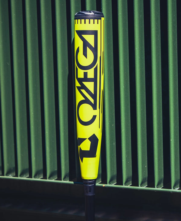2026 DeMarini Omega™ Electric Yellow -3 BBCOR Baseball Bat resting against a metal fence