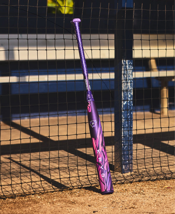 2026 Louisville Slugger KRYO Thundernight Fastpitch Bat leaning against a fence