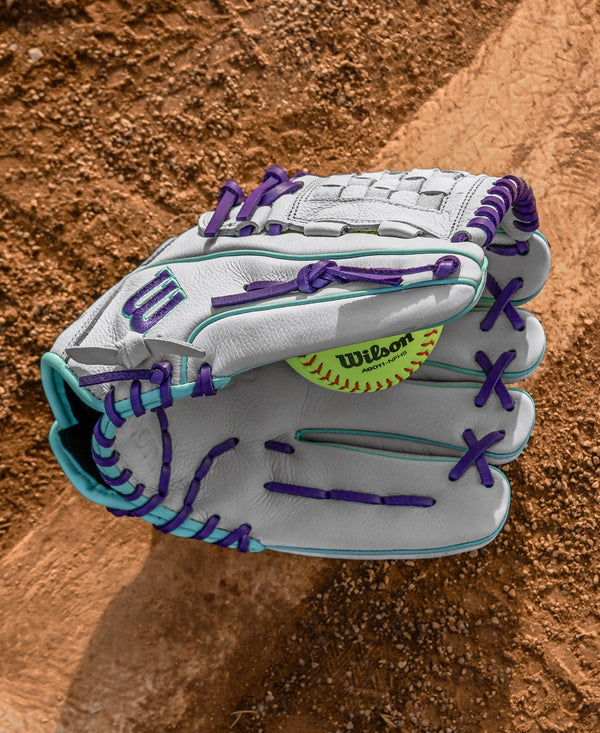 Wilson A500™ Siren 12" Youth Fastpitch Glove with a softball inside