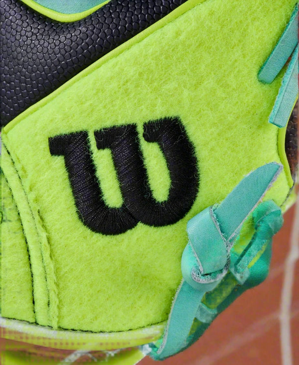 Close-up of the Wilson logo sewn onto the tennis ball felt on the front of the Wilson 2025 Tennis A2000® 1786SS 11.5" Baseball Glove