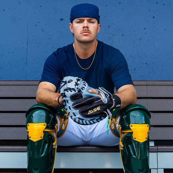 Player on the bench wearing the All Star Limited Pro Elite® Series 34" Baseball Catchers Mitt