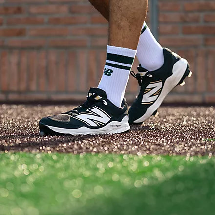 Close-up of a player walking while wearing the New Balance Fresh Foam 3000 v7 Molded Cleat - Black w/ White