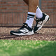 Close-up of a player walking while wearing the New Balance Fresh Foam 3000 v7 Molded Cleat - Black w/ White