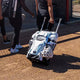 Fastpitch player rolling the Easton Jen Schro Catcher's Wheeled Bag towards the field