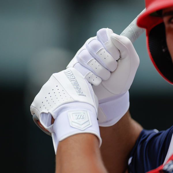 Player batting while wearing the Marucci Luxe Adult Batting Glove - White