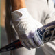 Player carrying a bat while wearing the Marucci Signature Adult Batting Glove - White