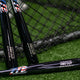 Three Marucci USA Professional Cut Wood Bats beside a batting cage