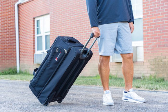 Man rolling the Force 3 Ultimate Equipment Bag with Wheels