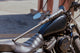 2026 Combat MFG Spec-H1 Steel Horses Shadow Rider Hybrid -3 BBCOR Baseball Bat resting on a motorcycle