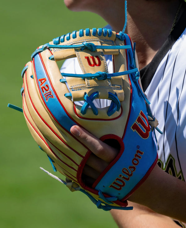 Player in the field wearing the Wilson 2027 A2K® 1786 11.5" Baseball Glove - Blonde/Sky Blue