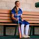Player in the dugout modeling the 2025 Easton Ghost OG Rainbow Sherbert Fastpitch Bat