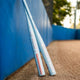 Two 2025 Easton Ghost Unlimited Fastpitch Bats leaning against a ballpark fence