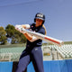 Front view of a premier fastpitch player swinging a 2025 Easton Ghost Unlimited Fastpitch Bat