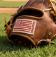 Close-up of the USA flag logo on the wrist of the Nokona Walnut Edge™ Precision 11.5" I-Web Baseball Glove
