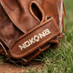 Close-up of the logo and wrist strap on the Nokona Walnut Edge™ Precision 32.5" Fastpitch Catchers Mitt