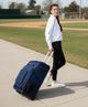 Woman rolling the Evoshield Takeover Utility Wheeled Bag - Black