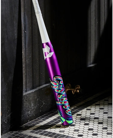 2025 DeMarini Spryte -12 Fastpitch Bat leaning against a wall