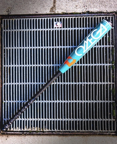 2026 DeMarini Omega -3 BBCOR Baseball Bat lying on a grate