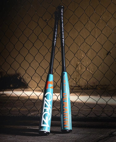 2026 DeMarini Omega -3 BBCOR Baseball Bats leaning against a fence