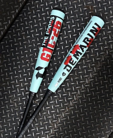 2026 DeMarini The Goods™ -3 BBCOR Baseball Bats lying on a metal surface