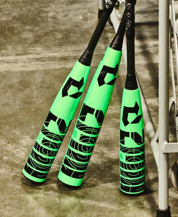 Three 2026 DeMarini Zen USSSA Baseball Bats leaning against a lattice