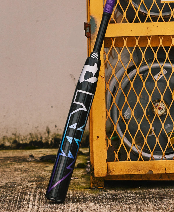 2026 DeMarini Prism+™ FE -11 Fastpitch Bat resting against a metal crate