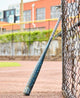 2025 Louisville Slugger Omaha -3 BBCOR Baseball Bat leaning against a fence