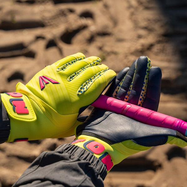 Player gripping a bat with the Easton Walk-Off Ethos Spring Break Youth Batting Gloves - Neon