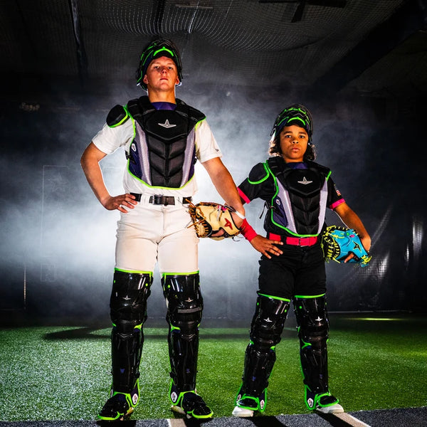 An older catcher and a younger catcher posing while wearing the All Star MVP-Pro™ Short Fuse Series Baseball Catching Kits- Jokester