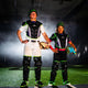 An older catcher and a younger catcher posing while wearing the All Star MVP-Pro™ Short Fuse Series Baseball Catching Kits- Jokester