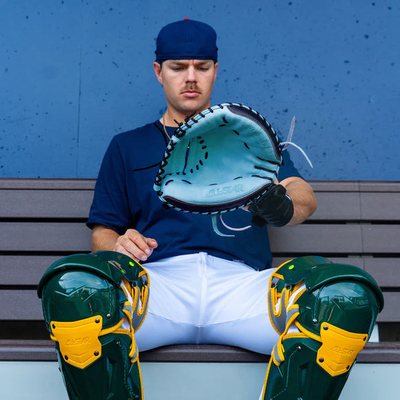 Player on the bench checking out the All Star Limited Pro Elite® Series 34" Baseball Catchers Mitt