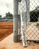 2025 Warstic Bonesaber Composite USSSA Baseball Bat leaning against a ballpark fence