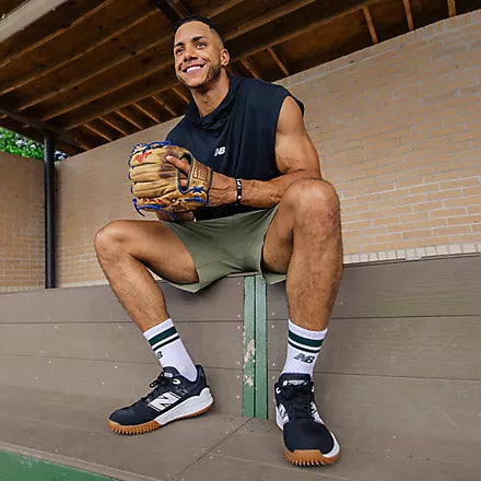 Player in the dugout wearing the New Balance Fresh Foam 3000 v7 Men's Turf/Trainer - Black with White