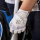 Player getting out his bat while wearing the Marucci Signature Youth Batting Glove - White